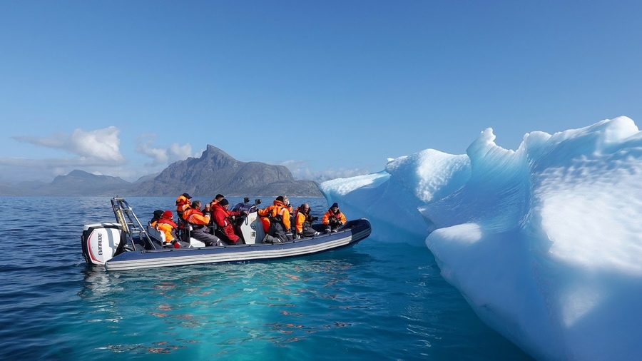 Menschen auf Boot betrachten Eisberg